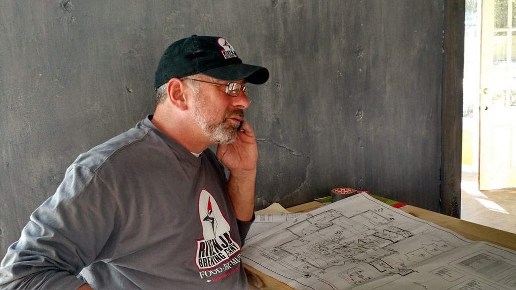 Rikenjaks owner Jay Ecker discussing blueprints with a contractor. 